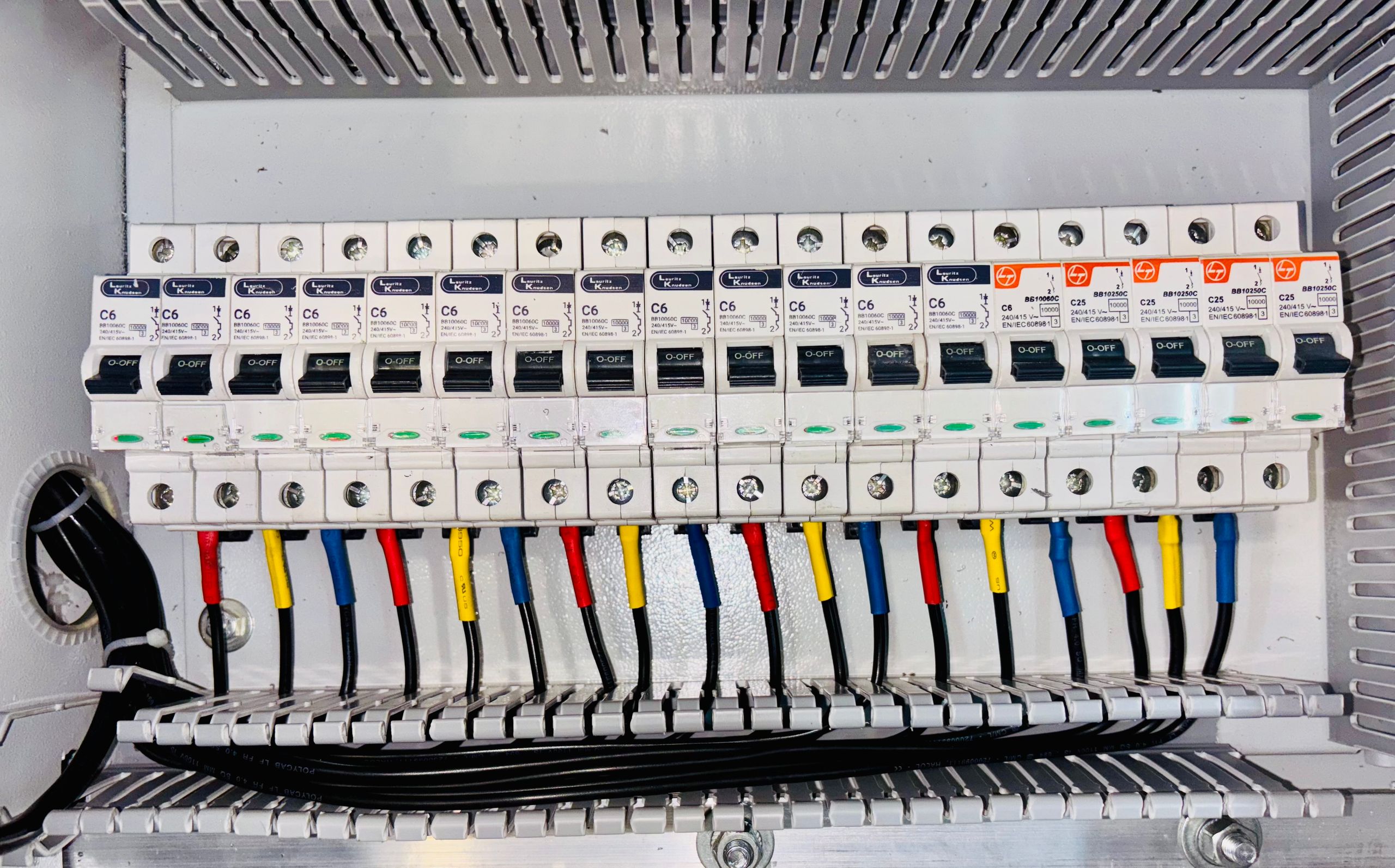 DIN ray üzerine monte edilmiş şalter grubu ve renk kodlu kablolamayla elektrik panosu